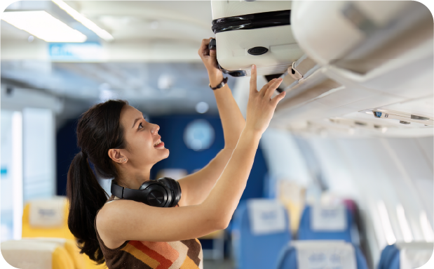 Mujer acomodando maleta de cabina dentro de avión JetSMART
