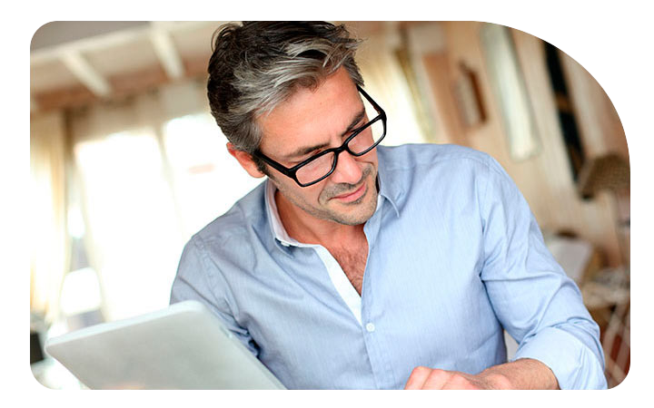 Hombre leyendo sentado en su escritorio