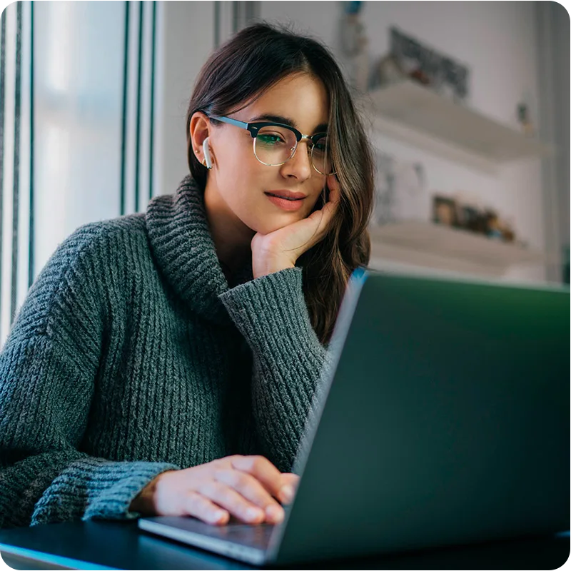 Mujer con audífonos mirando computador