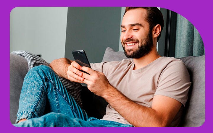Hombre sonriendo con celular en la mano