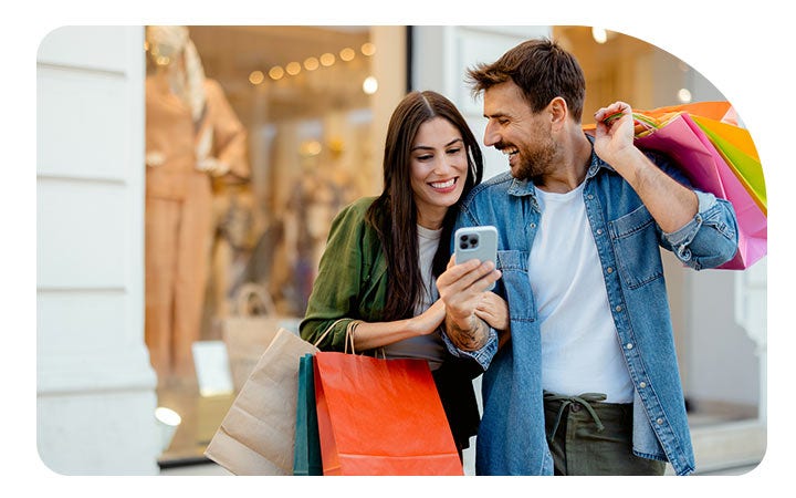Mujer con una tarjeta de crédito revisando su celular 