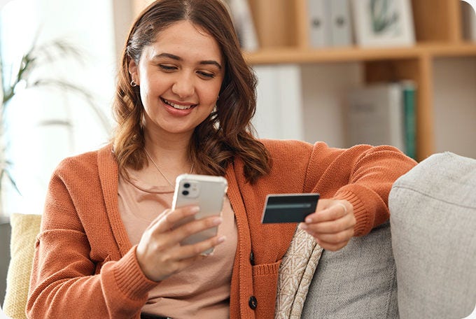 Mujer con celular y Tarjeta de Crédito BancoEstado