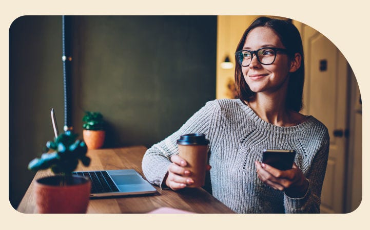 Mujer sonriendo con un celular en la mano