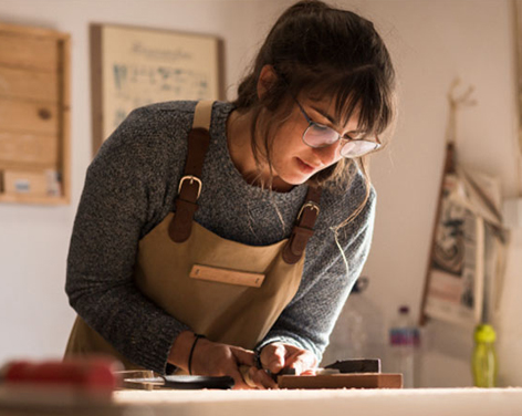 Mujer trabajando en madera sobre una mesa