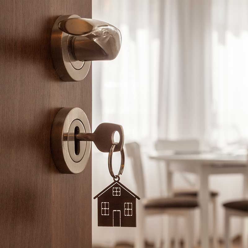 Puerta de una vivienda con llaves puestas en chapa, al fondo se ve mesa con sillas Puerta de una vivienda con llaves puestas en chapa, al fondo se ve mesa con sillas