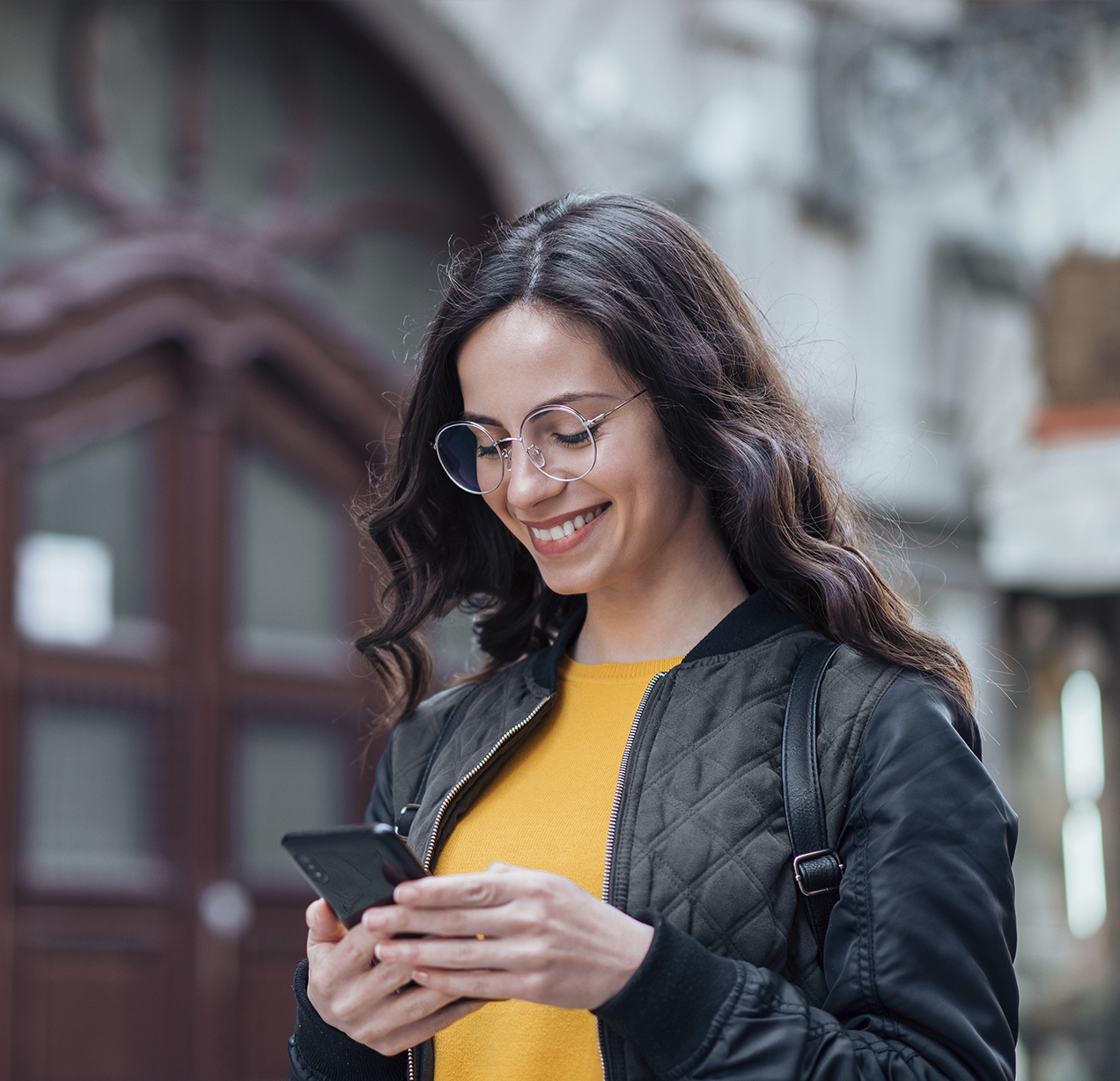 Mujer sonriendo mirando su celular