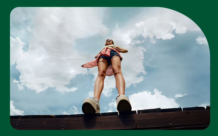 Mujer vista desde abajo bajo el cielo azul