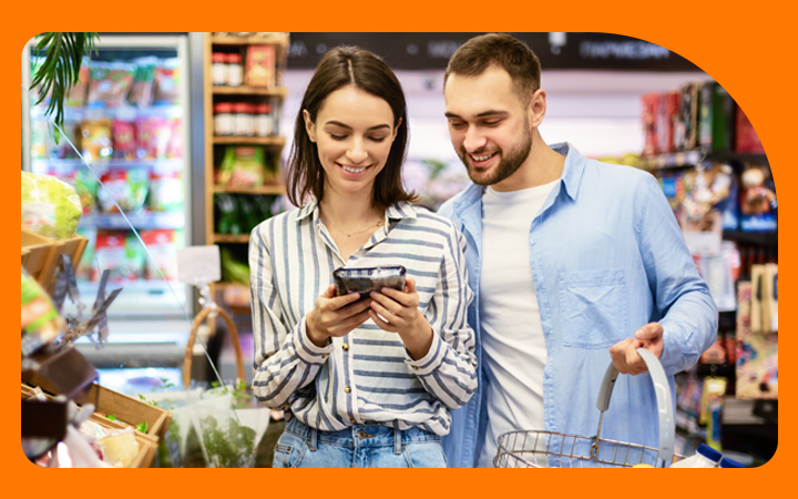 Pareja revisando un celular en supermercado