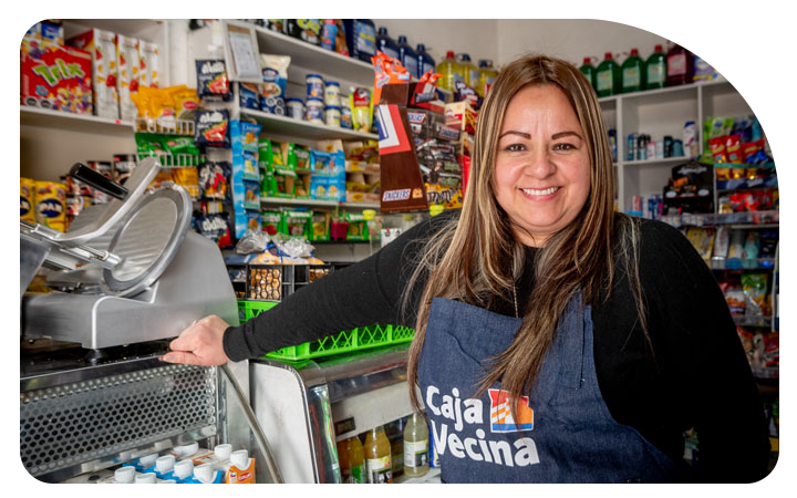 Mujer operadora de CajaVecina posando alegre en su local