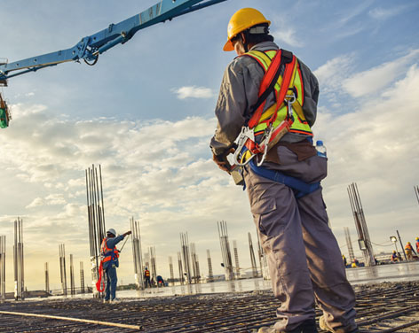 Hombre trabajando en una gran obra con cascos de seguridad