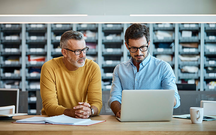 Dos hombres mirando pantalla de un computador