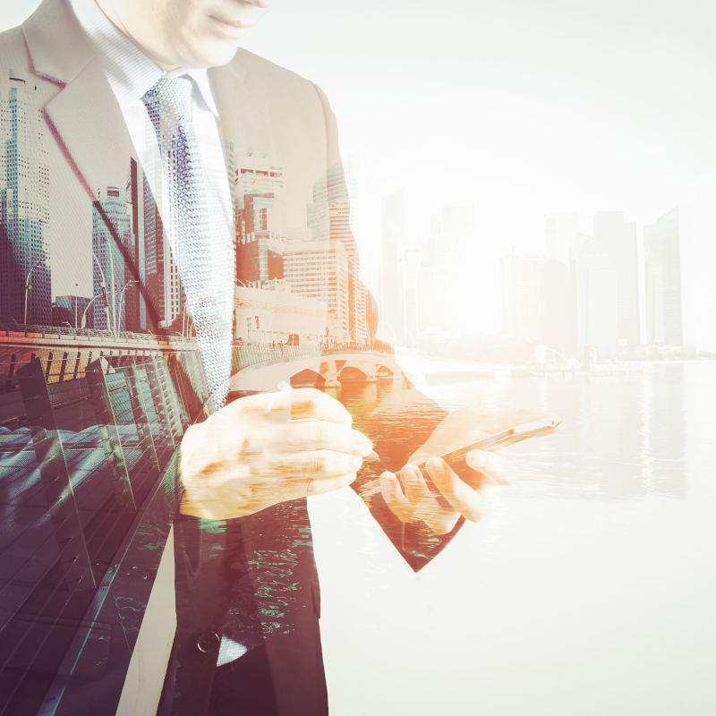 Hombre revisando estadísticas. Sobre él se superpone una imagen de ciudad