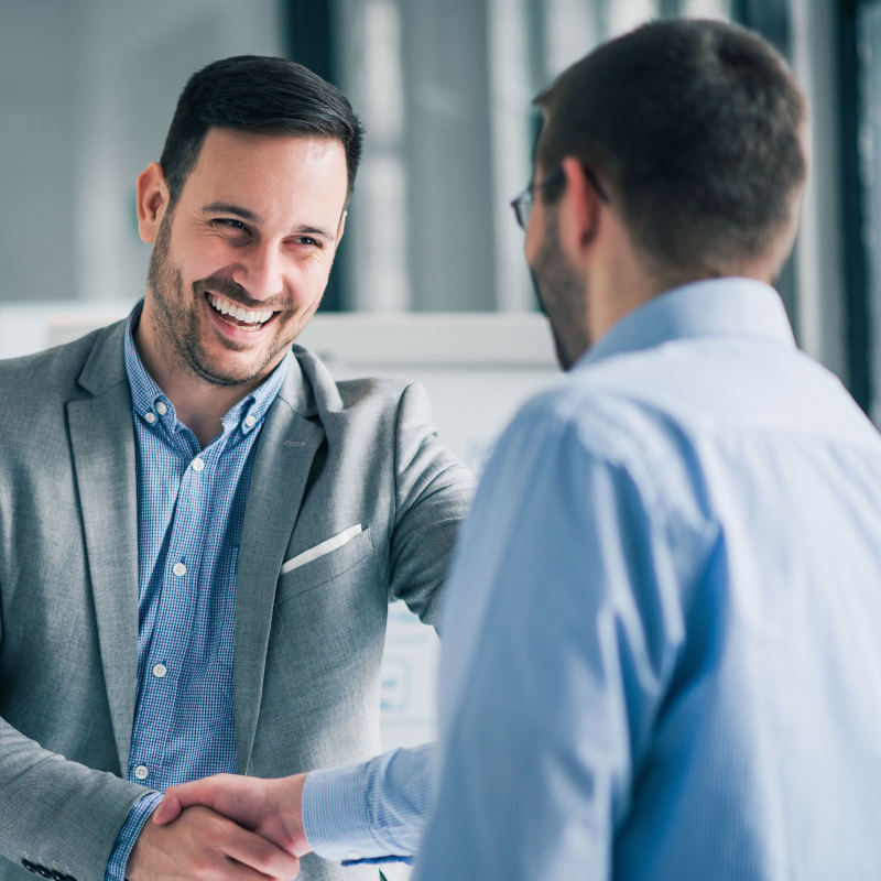 Dos hombres estrechándose la mano en una oficina Dos hombres estrechándose la mano en una oficina