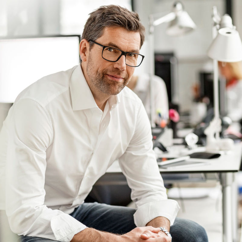 Hombre sonriendo en el escritorio de su oficina Hombre sonriendo en el escritorio de su oficina