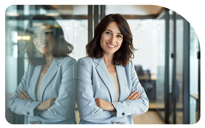 Mujer sonriendo apoyada a una puerta transparente